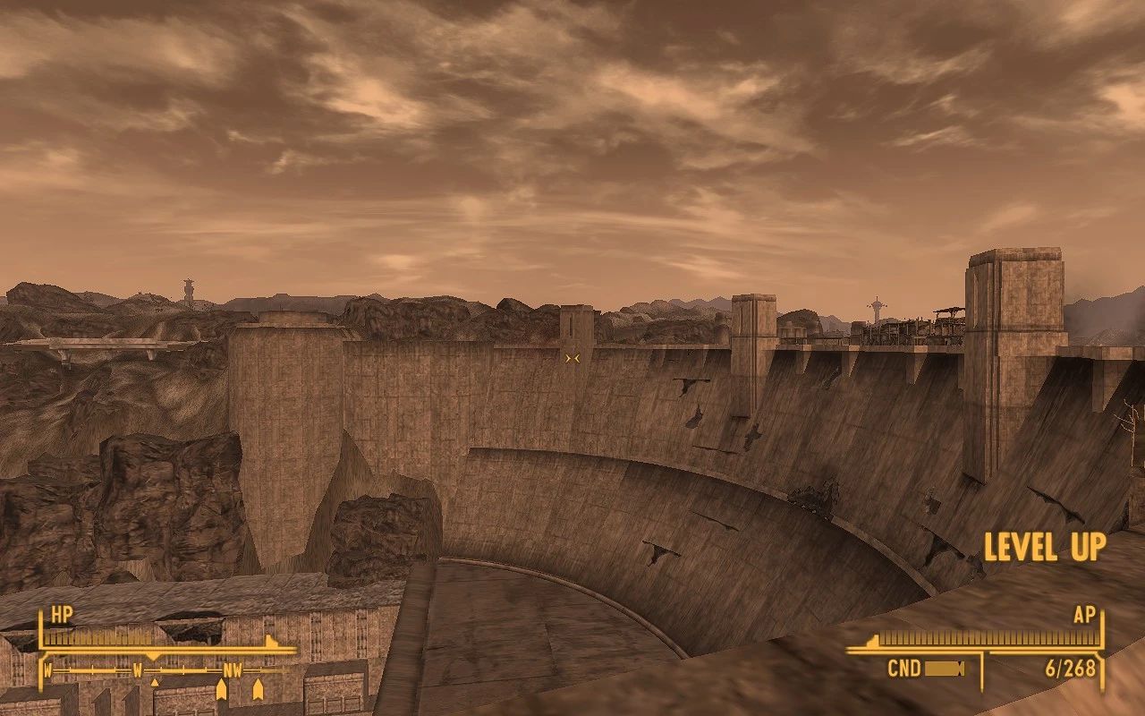 A view of a large, weathered dam set against a rugged, rocky landscape under a cloudy, sepia-toned sky.
