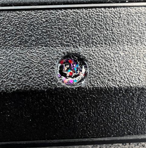 Photo of a screw that’s been covered with a unique pattern of (multi-color) glitter nail polish
